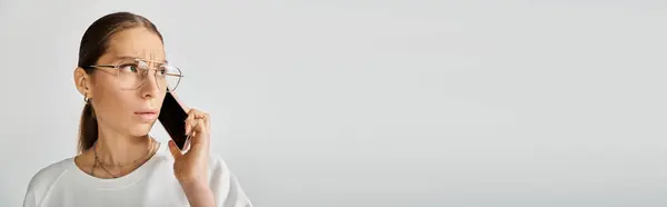 Młoda Kobieta Okularach Biała Koszulka Rozmawiająca Przez Komórkę Szarym Tle — Zdjęcie stockowe