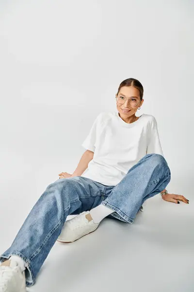 Ung Kvinde Sidder Jorden Hvid Skjorte Jeans Overvejer Ensomhed Grå - Stock-foto