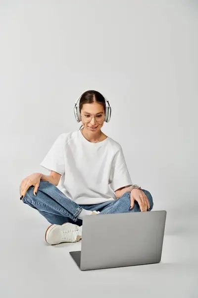 Wanita Muda Berkaos Putih Dan Berkacamata Duduk Lantai Dengan Laptop — Stok Foto