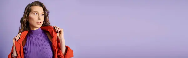 一个穿着紫色衬衫和红色夹克 衬托着充满活力的紫色背景的时髦年轻女人 — 图库照片