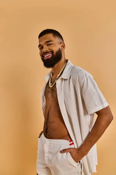 stock image A man with a full beard strolls confidently, wearing white shorts in a casual, relaxed manner.