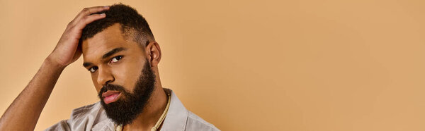 Созерцательный человек с бородой держит голову в руках, глубоко погруженный в мысли или мучения, размышляя о сложностях жизни.