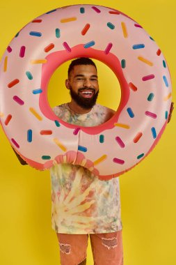 A man playfully hides his face behind a massive donut, showcasing his whimsical and humorous side while enjoying a tasty treat. clipart