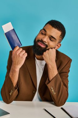 A man in casual attire sits at a wooden table, engrossed in a book he holds in his hands, deep in thought and reflection. clipart