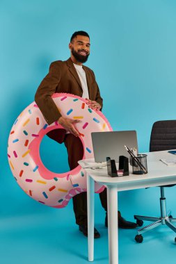 Bir adam masada oturuyor, önünde kocaman bir çöreğe bakıyor. Donut hayattan daha büyük, cezbedici ve gerçeküstü..