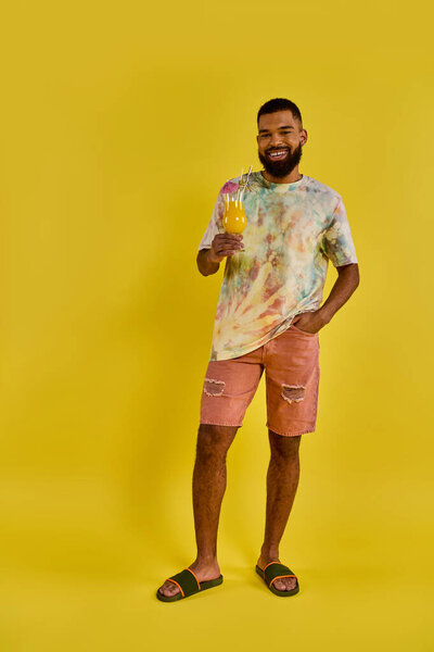 A solitary man stands in front of a vibrant yellow background, his silhouette stark against the bright color.