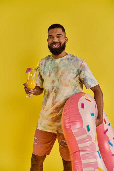 A sophisticated man holding a glass of wine, standing next to an inflatable flamingo in a pool, enjoying a moment of relaxation and leisure.