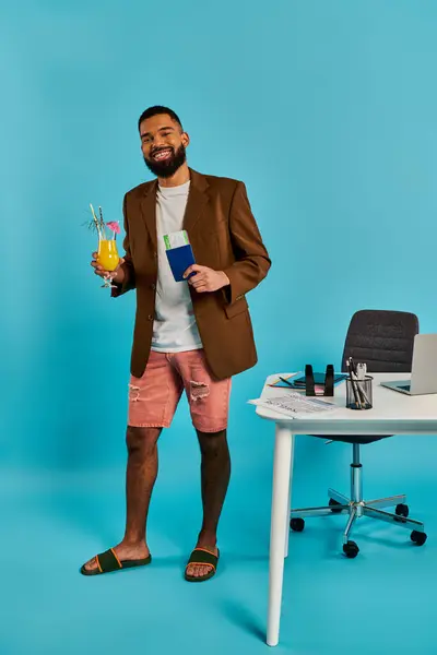 ビジネス服を着ている男性は 洗練された机の前に自信を持って立って 彼の顔に熟考的な表現でカップを保持しています — ストック写真