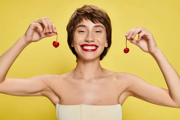 Young Woman Striking Pose Cherry Balanced Her Head Vibrant Backdrop — Stock Photo, Image