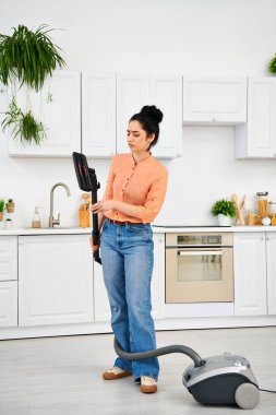 Günlük kıyafetleri içinde şık bir kadın mutfak zeminini süpürüyor, günlük ev işlerine zarafet katıyor..