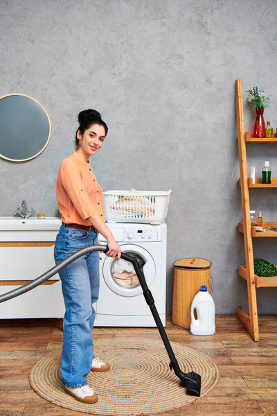A stylish woman in casual attire effortlessly cleans the floor using a vacuum cleaner.
