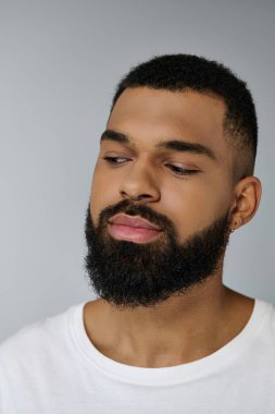 Close up of a handsome young man grooming his beard. clipart