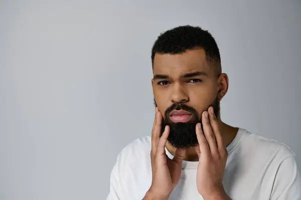 Stock image Handsome man with beard savoring his skincare routine.