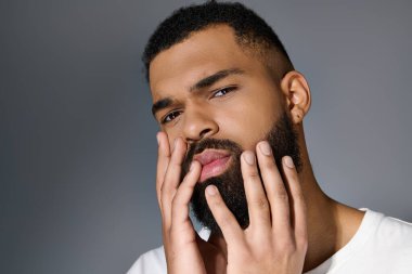 A close-up of a man with a beard taking care of his skin. clipart