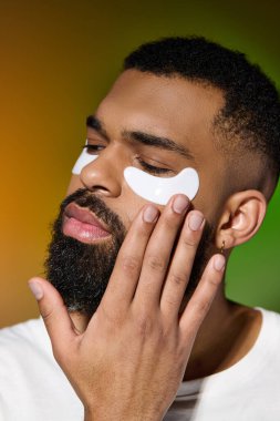 Yüzünde göz bandı olan yakışıklı genç bir adam, benzersiz tarzını sergiliyor..