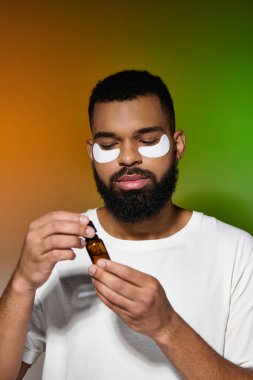 African american handsome man using eye patches and serum. clipart