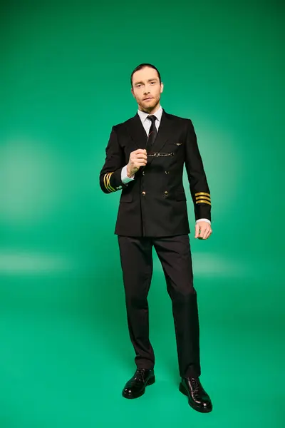 Handsome Male Pilot Black Uniform Strikes Pose Vibrant Green Backdrop — Stock Photo, Image