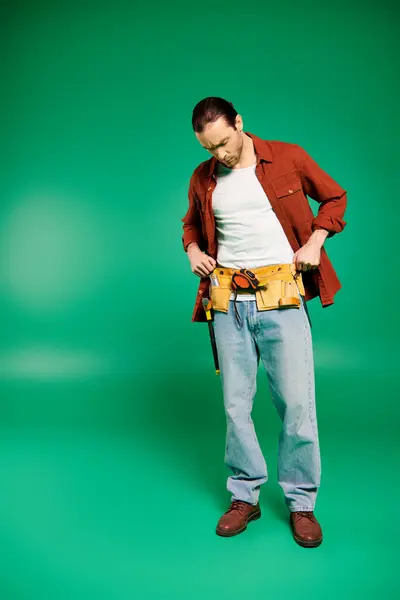 Ein Mann Uniform Steht Selbstbewusst Mit Werkzeug Vor Sattgrünem Hintergrund — Stockfoto