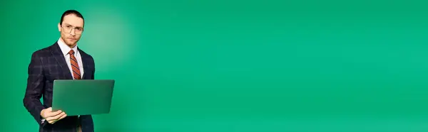 Красивый Бизнесмен Шикарном Костюме Держит Ноутбук Зеленом Фоне — стоковое фото
