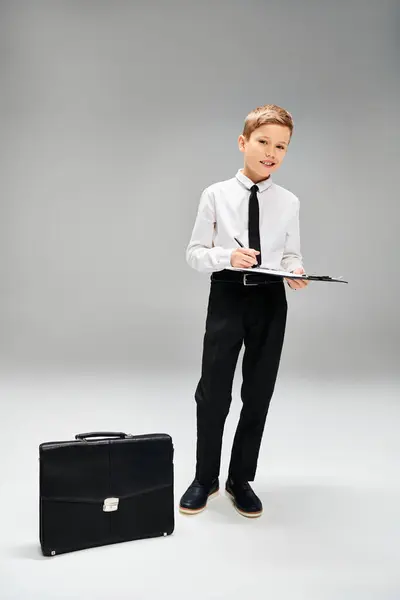 Preadolescent Boy Elegant Attire Holds Paper Next Suitcase — Stock Photo, Image