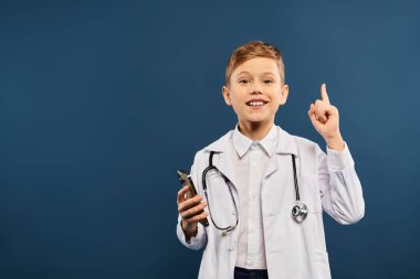Doktor önlüklü çocuk coşkuyla işaret ediyor..
