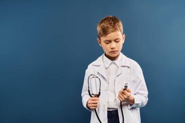 Doktor gibi giyinmiş, steteskop tutan genç bir çocuk..