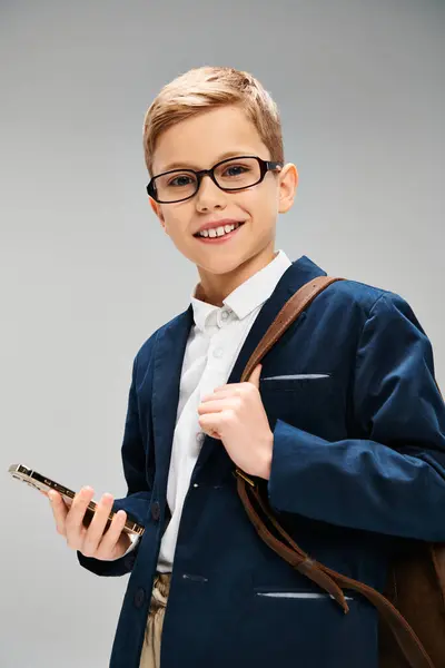 Ung Pojke Glasögon Håller Mobilen Affärsidé Grå Bakgrund — Stockfoto