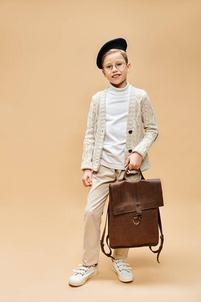 Preadolescent boy dressed as film director holds a brown briefcase.
