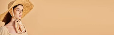 Uzun esmer saçlı genç bir kadın, şık bir hasır şapka ve dalgalı bir eşarp takarak yaz kıyafetiyle poz veriyor..