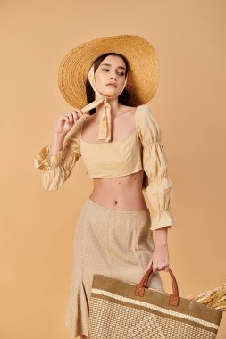 Young woman with long brunette hair exudes summer vibes, holding a straw bag in a stylish straw hat. clipart