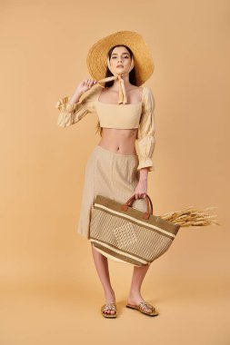 A young woman with long brunette hair poses confidently in a summer outfit, holding a basket and wearing a stylish straw hat. clipart