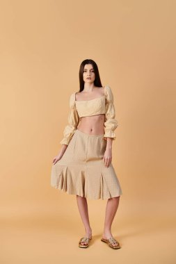 A young woman with long brunette hair strikes a pose in a summer outfit consisting of a skirt and crop top, exuding a vibrant summer mood. clipart