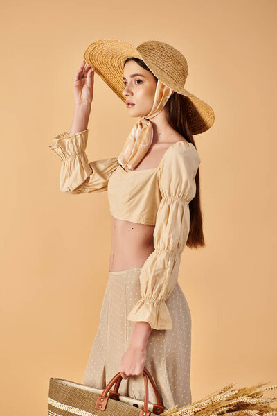 A stylish young woman with long brunette hair striking a pose in a summer outfit, complete with a straw hat and handbag.