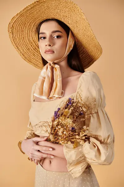 stock image A young woman with long brunette hair exudes a summer vibe as she holds a bouquet of flowers wearing a straw hat.