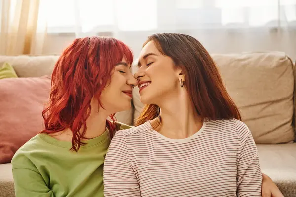 Mutlu genç lezbiyen çiftin mutlu anları. Gözleri kapalı evde gülümsüyorlar. Mutluluk ve sevgi dolu.