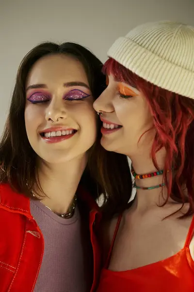Stylowa Młoda Lesbijka Para Odważnym Makijażem Uśmiechnięta Szarym Tle Dzieląca — Zdjęcie stockowe