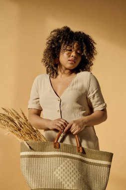 A beautiful young African American woman with curly hair holding a basket with a handle in a studio setting. clipart