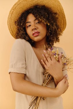 A beautiful young African American woman with curly hair wearing a straw hat, holding a bunch of colorful flowers. clipart