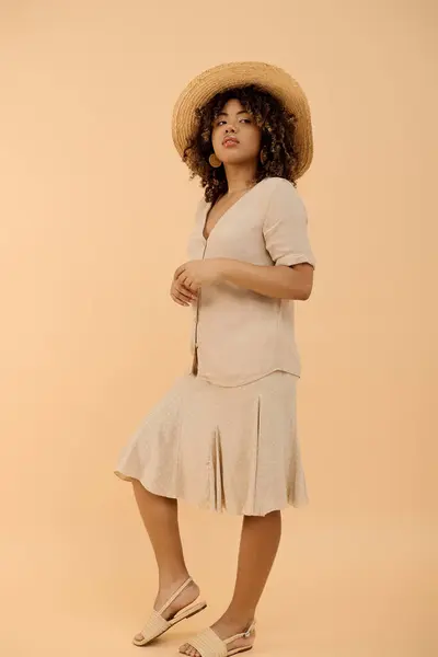 一位年轻时髦的非洲裔美国女人 穿着夏装 头戴礼帽 在工作室里自信地摆姿势 — 图库照片