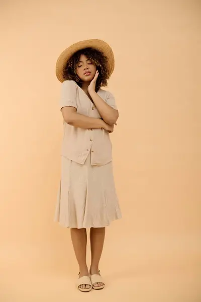 一位头发卷曲的美丽的非洲裔美国妇女在工作室里戴着一顶帽子和一件夏装 — 图库照片
