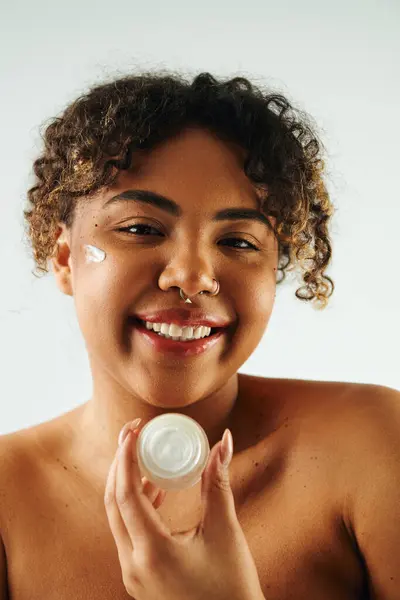 在充满活力的背景下 非裔美国女人精力充沛地拿着奶瓶 — 图库照片