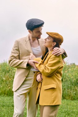Bir erkek ve kadın, yeşillik ve doğanın güzelliği ile çevrili, pitoresk bir alanda hassas bir anı paylaşıyor..
