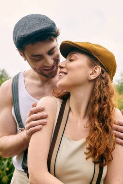 A man and a woman standing closely, embraced in a romantic moment in a verdant park setting. clipart