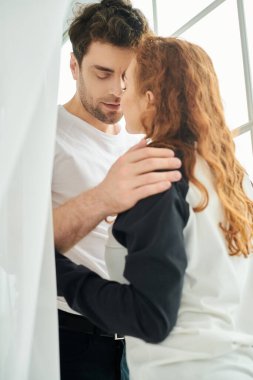 Bir erkek ve bir kadın birbirine yakın duruyor, sessiz bir yakınlık ve bağ anlarını paylaşıyorlar..