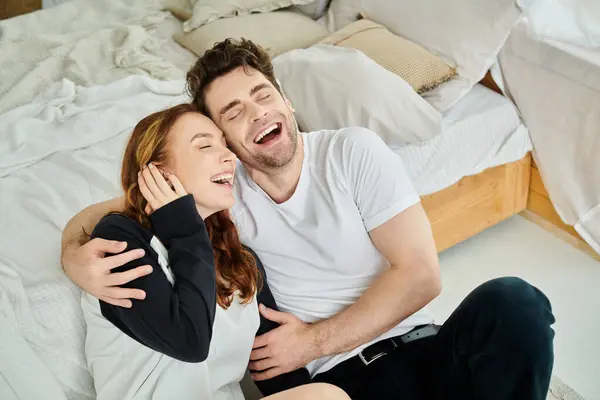 stock image A man and a woman enjoy a peaceful moment, sitting on their bed, deep in conversation, surrounded by warmth and intimacy.