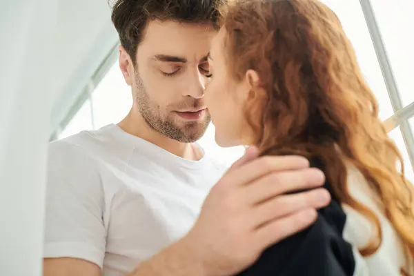 stock image A man and a woman stand side by side, exuding unity and connection in a serene bedroom setting.