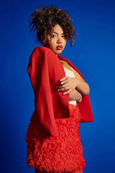 stock image debonair african american woman with collected hair in vibrant elegant attire looking at camera