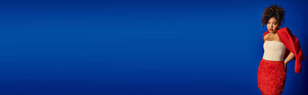 chic african american woman with collected hair in vibrant elegant attire looking at camera, banner