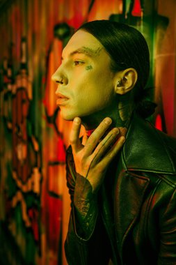 Göğsünde elleri olan siyah deri ceketli bir adam.