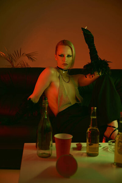 Женщина сидит за столом с несколькими бутылками вина перед ней